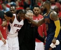 Cleveland Cavaliers forward LeBron James, right, speaks with an injured Atlanta Hawks forward DeMarre Carroll (5) as Carroll is helped of the court during the second half in Game 1 of the Eastern Conference finals of the NBA basketball playoffs, Wednesday, May 20, 2015, in Atlanta. (AP Photo/John Bazemore) 
